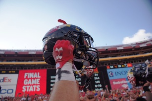 A Maryland player holds his helmet to the sky after the Terrapins' surprise victory over the Texas Longhorns. (Photo by Jake Russell)